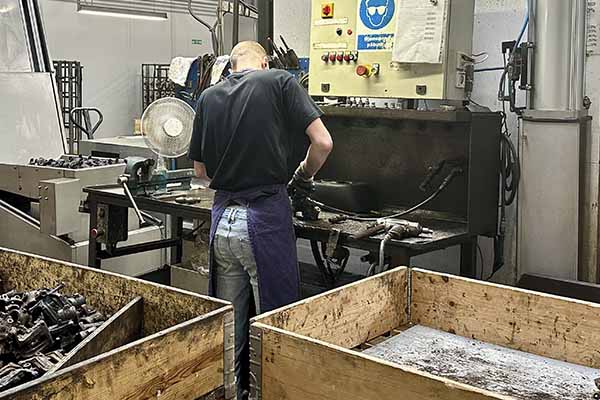 En medarbejder i gang med at rense en bremsekaliber